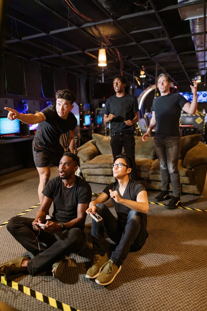 Five young adults gaming together in an arcade setting, enjoying teamwork and technology.